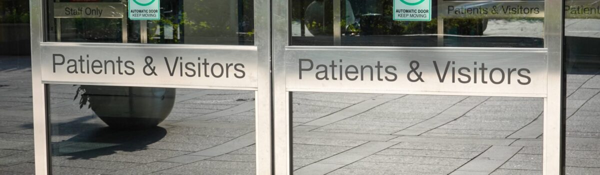 Automatic,Sliding,Glass,Door,Entrance,To,A,Hospital,That,Says