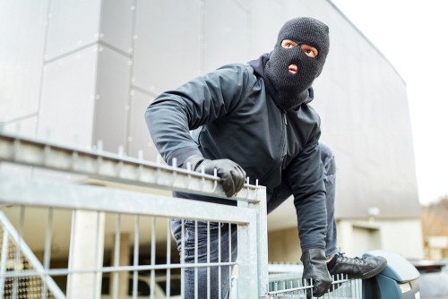 Masked,Burglar,Climbs,Over,A,Fence,During,Burglary